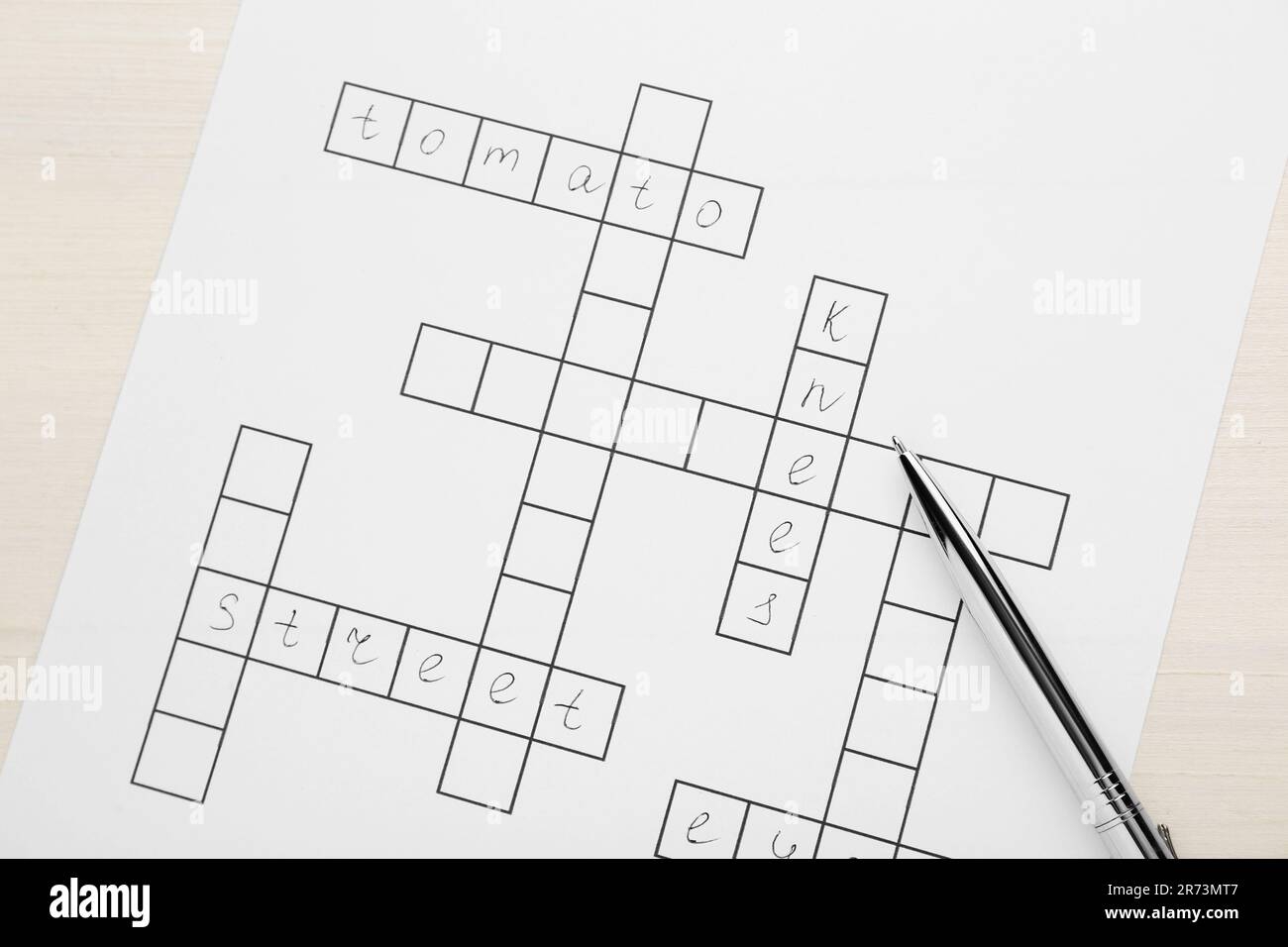 Crossword With Answers And Pen On White Wooden Table Top View Stock Photo Alamy